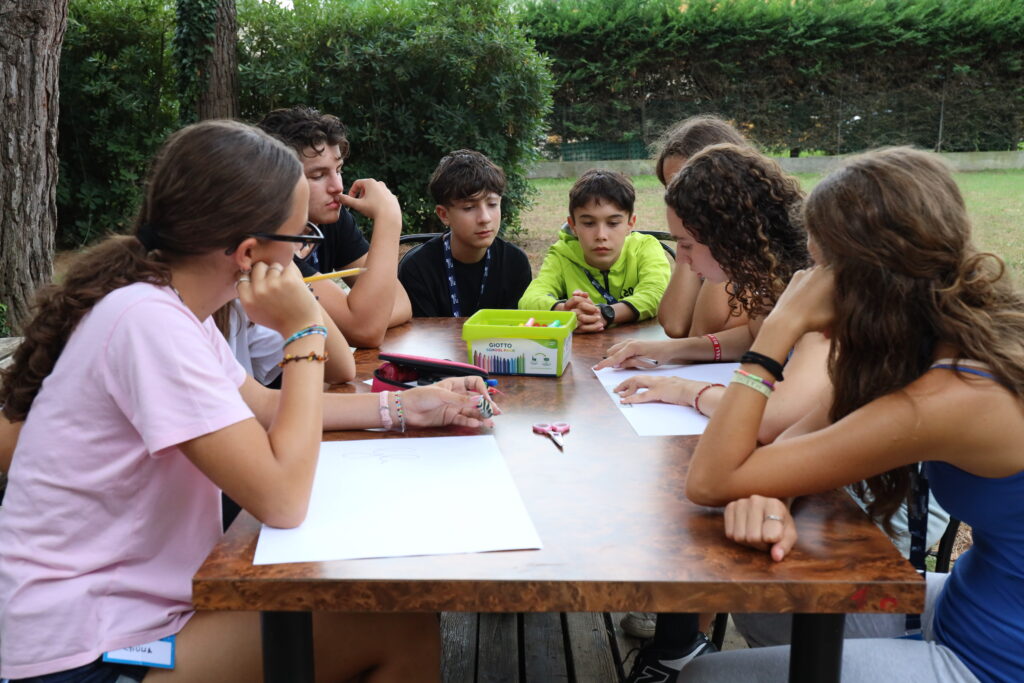 Ragazzi del SicuraMente Campus lavorano insieme attorno a un tavolo